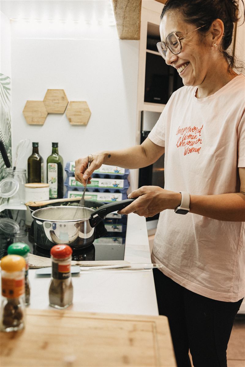Tamara souriante en train de cuisiner sur la plaque de cuisson